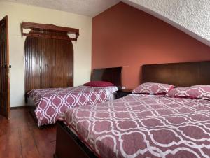 una habitación de hotel con 2 camas en una habitación en ALOJAMIENTOS HOSTAL REST HOUSE, en Cuenca