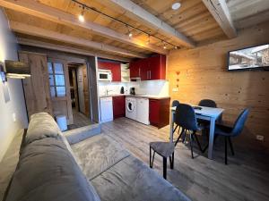 ラ・クリュサにあるParnasse 2-203 - Bel appartement sur les pistes de ski et dans le village, au calmeのリビングルーム(ソファ、テーブル付)、キッチンが備わります。