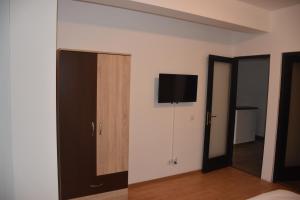 ein Schlafzimmer mit einem Flachbild-TV an der Wand in der Unterkunft Pensiunea Sasha in Bîrnova