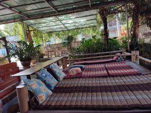 an outdoor bed in a pergola with pillows at topp stay hostel in Pai