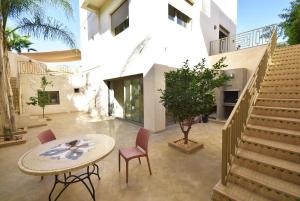 una casa con mesa, sillas y escaleras en Villa Délice, en Marrakech