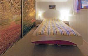 a bed in a room with a painting on the wall at 2 Bedroom Awesome Apartment In Kårhamn in Vatna