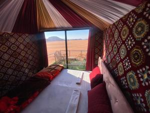 Una habitación con sofá y vista al desierto. en Desert shine camp, en Wadi Rum