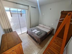 Habitación pequeña con cama y ventana grande. en Residencial Praia Brava Blue - Apartamentos, en Balneário Camboriú