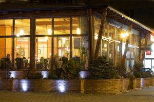 a building with a lot of windows at night at Restaurant Pensiune Bucovina in Câmpulung Moldovenesc