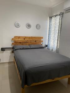 1 dormitorio con 1 cama grande y cabecero de madera en Departamento nuevo con excelente ubicación!, en Mazatlán