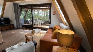 a living room with a couch and a table at Wald-Chalet Vulkaneifel in Kerschenbach