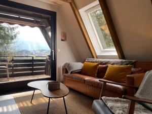 sala de estar con sofá y ventana grande en Wald-Chalet Vulkaneifel, en Kerschenbach