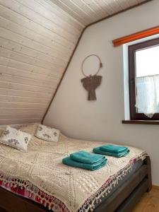 a bedroom with a bed with green pillows on it at Dwernik Bukowina Bieszczady in Dwernik