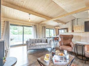 a living room with a couch and a table at Treetops Luxury Log Cabin - Hot tub, BBQ & Sauna in Kippford