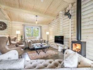a living room filled with furniture and a fireplace at Treetops Luxury Log Cabin - Hot tub, BBQ & Sauna in Kippford