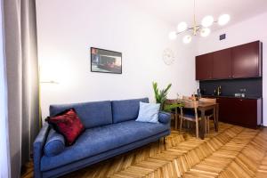 - un salon avec un canapé bleu et une table dans l'établissement Unique Style Apartments Old Town - 25 min from the airport - by Homelike Krakow, à Cracovie