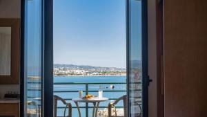 balcón con mesa y vistas al océano en Arocaria Apartments, en La Canea