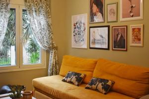 - un canapé dans le salon avec des photos sur le mur dans l'établissement Vintage Apartment, à Athènes
