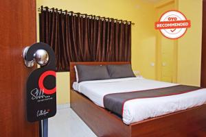 a bed in a room with a sign next to a door at Gokul Residency Near Emami City Nager bazar in Dum Dum