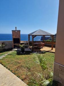 un patio con cenador y el océano en Appartement océan Esparon, en Petite Île