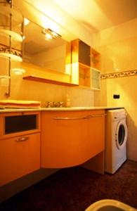 a kitchen with a sink and a washing machine at Sandra Villa Rooms in Corniglia