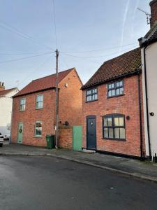 a brick house with a door on a street at Bieldside Cottage in Ollerton