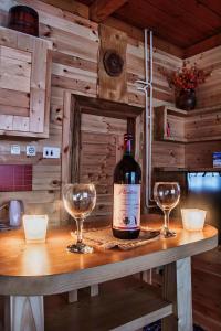 a bottle of wine sitting on a table with two glasses at Apartments Life in Kolašin