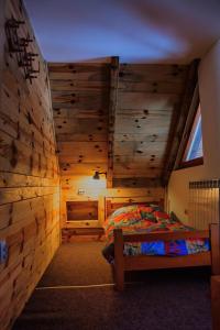 ein Schlafzimmer mit einem Bett in einem Zimmer mit Holzwänden in der Unterkunft Apartments Life in Kolašin
