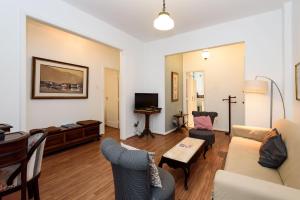 a living room with a couch and chairs and a tv at 2 Quartos/ 2 banheiros Entre Copa Ipanema Arpoador in Rio de Janeiro