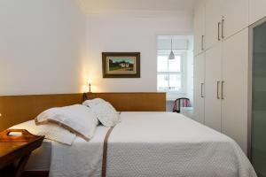 a bedroom with a bed with white sheets and pillows at 2 Quartos/ 2 banheiros Entre Copa Ipanema Arpoador in Rio de Janeiro