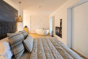 een slaapkamer met een groot bed en een bad bij TheVagar Countryhouse in Belmonte