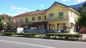un gran edificio amarillo en el lateral de una calle en Hotel Paradise en Bruzolo