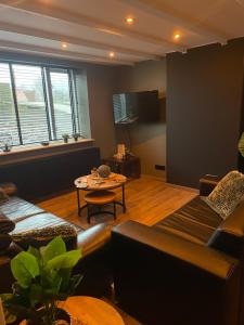 uma sala de estar com um sofá e uma mesa em Graafjansdijk B Vakantiehuis met 3 slaapkamers net over de Belgische grens em Westdorpe