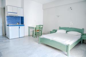 1 dormitorio con 1 cama y cocina con mesa en Korali Garden, en Naxos Chora