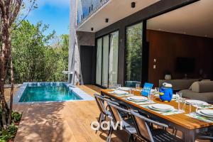 mesa de comedor con sillas junto a la piscina en Qavi - Casa luxuosa em condomínio fechado na praia da Pipa - #Maxlife09, en Pipa