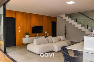 sala de estar con sofá blanco y TV en Qavi - Casa luxuosa em condomínio fechado na praia da Pipa - #Maxlife09, en Pipa