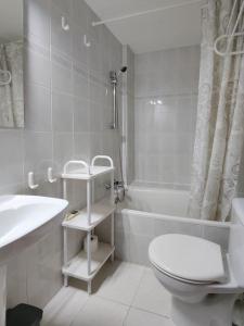 ein weißes Badezimmer mit einem WC, einer Badewanne und einem Waschbecken in der Unterkunft Cómodo apartamento en el centro - Gran Vía in Madrid