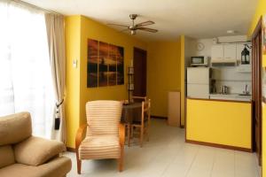 ein Wohnzimmer mit einem Sofa und eine Küche mit gelben Wänden in der Unterkunft Cómodo apartamento en el centro - Gran Vía in Madrid
