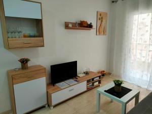 a living room with a flat screen tv on a cabinet at Casas Holiday - Playa del Cura in Torrevieja