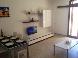 a living room with two tables and a tv at Fort Chambray Apartment in Għajnsielem