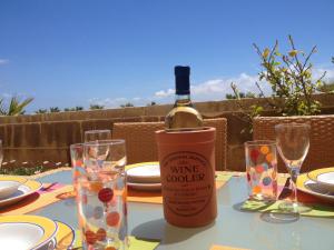 a bottle of wine sitting on a table with glasses at Fort Chambray Apartment in Għajnsielem