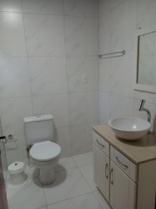 Baño blanco con aseo y lavamanos en Estúdio Palace Hotel Canela, en Canela