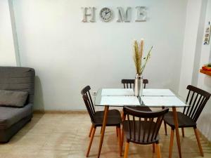 a dining room table with chairs and a vase with flowers at Casas Holiday - Playa del Cura in Torrevieja