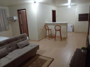 a living room with a couch and a kitchen at Estúdio Palace Hotel Canela By Cia da Temporada in Canela