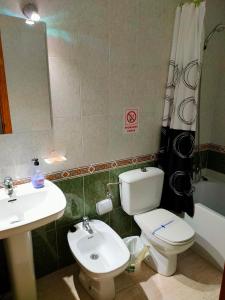 a bathroom with a toilet and a sink and a mirror at Casas Holiday - Playa del Cura in Torrevieja