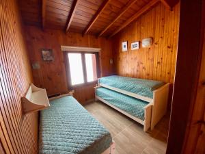 a room with two beds in a wooden cabin at Casa Ibañez in Villa Gesell