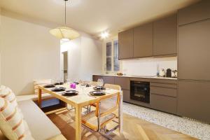 Amazing apartment 8P3BDR - MontmartreSacré cœur في باريس: مطبخ مع طاولة مع كؤوس للنبيذ عليه