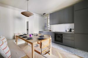 Amazing apartment 8P3BDR - MontmartreSacré cœur في باريس: مطبخ وطاولة خشبية عليها أكواب