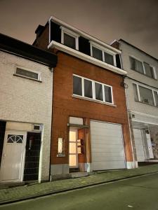 a brick house with a garage on a street at Appartement avec extérieur à proximité de Liège in Herstal