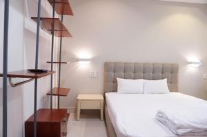 a bedroom with a large white bed and a table at Amango Home in Ho Chi Minh City