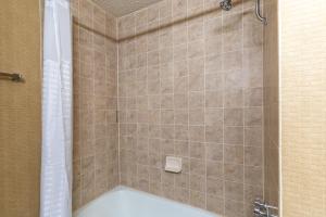 a bathroom with a shower with a tub at Ramada by Wyndham Reno Hotel & Casino in Reno