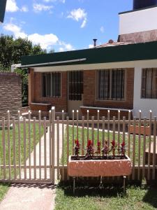 una cerca con una maceta delante de una casa en Casa en Villa Carlos Paz solo apto para familias en Córdoba