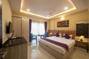 Zenith Hotels Hebbal Bangalore في بانغالور: غرفة فندقية بسرير كبير وطاولة