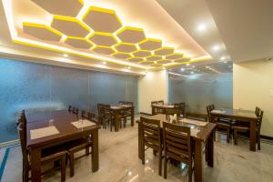a dining room with tables and chairs and a ceiling at Zenith Suites in Bangalore